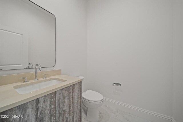 43 Del Palma Dr, Palm Coast, FL 32137 - bathroom with marble look tile flooring, toilet, vanity, and baseboards