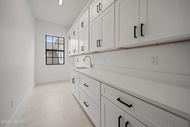 43 Del Palma Dr, Palm Coast, FL 32137 - kitchen with a sink, baseboards, light countertops, and white cabinets