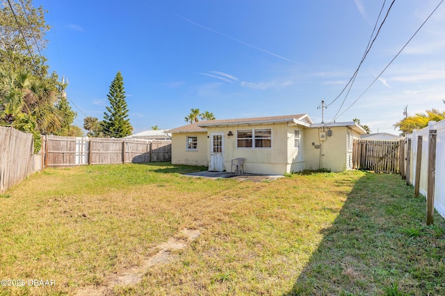 rear view of property featuring a lawn