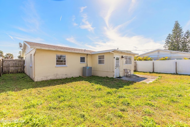 back of property with central AC, a yard, and a patio area