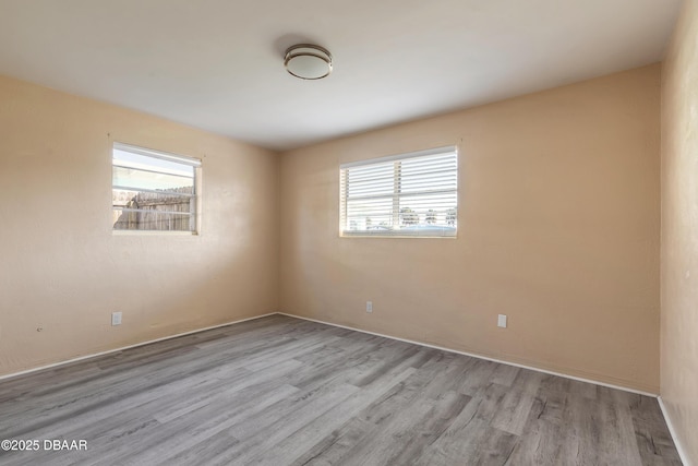 unfurnished room featuring a healthy amount of sunlight and light hardwood / wood-style floors