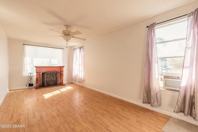 unfurnished living room with cooling unit, light hardwood / wood-style floors, and a healthy amount of sunlight