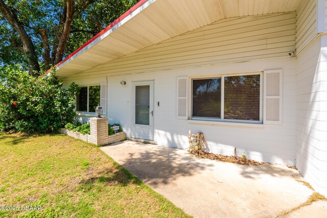 1496 Granada Ave, Daytona Beach, FL 32117 - doorway to property with a patio and a yard