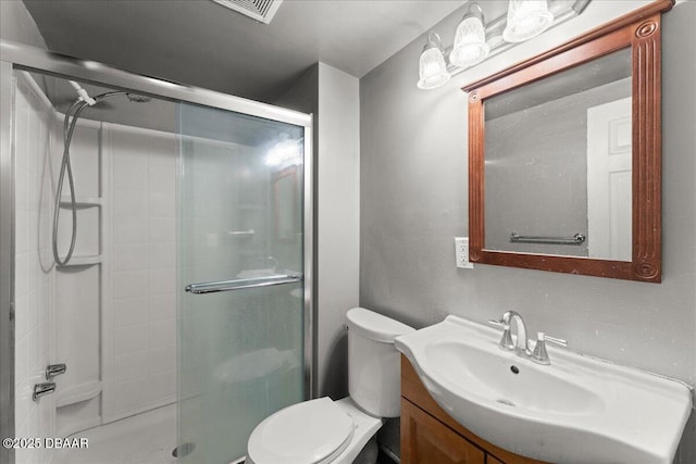 bathroom with a stall shower, toilet, and vanity
