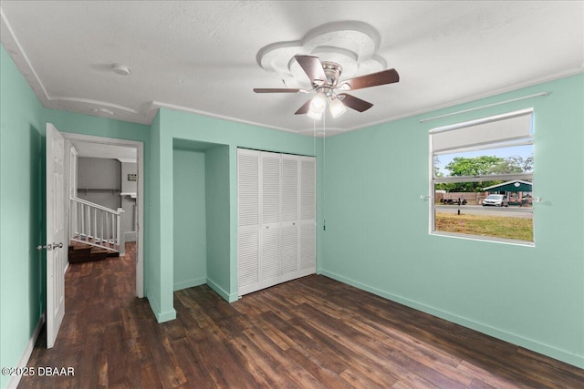 unfurnished bedroom featuring a closet, wood finished floors, baseboards, and a ceiling fan