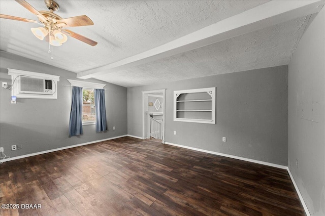 spare room featuring a textured ceiling, a ceiling fan, an AC wall unit, beamed ceiling, and wood finished floors