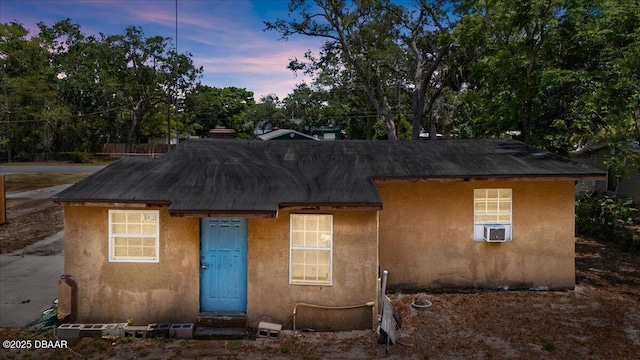 view of front of home featuring stucco siding and cooling unit