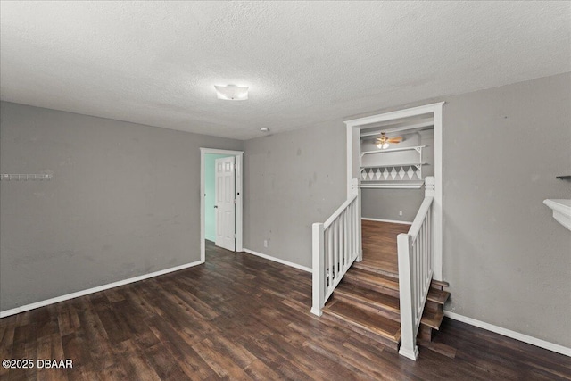 below grade area featuring wood finished floors, a textured ceiling, and baseboards