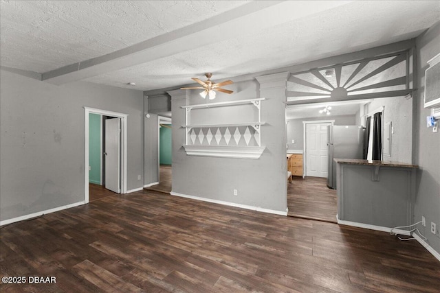 unfurnished living room with wood finished floors, a ceiling fan, baseboards, and a textured ceiling