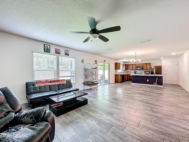 153 Orient Dr, Saint Augustine, FL 32092 - living area with a chandelier, ceiling fan, and a textured ceiling