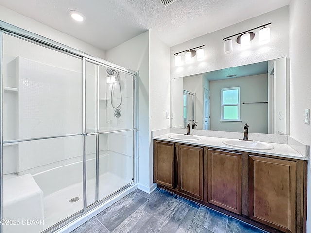153 Orient Dr, Saint Augustine, FL 32092 - bathroom with double vanity, a stall shower, and a textured ceiling