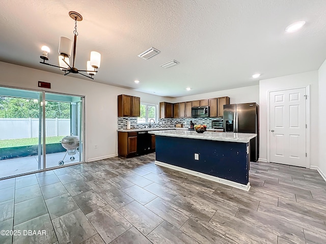 153 Orient Dr, Saint Augustine, FL 32092 - kitchen with a chandelier, backsplash, a kitchen island, black dishwasher, and recessed lighting