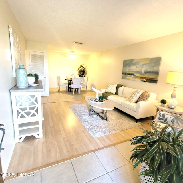 tiled living room featuring a textured ceiling