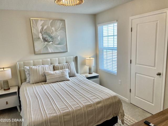 carpeted bedroom featuring baseboards and a notable chandelier