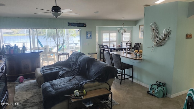 living room featuring light tile patterned flooring, ceiling fan, and sink