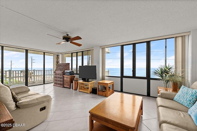 tiled living room featuring ceiling fan and a textured ceiling