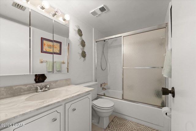 full bathroom with vanity, tile patterned flooring, bath / shower combo with glass door, and toilet