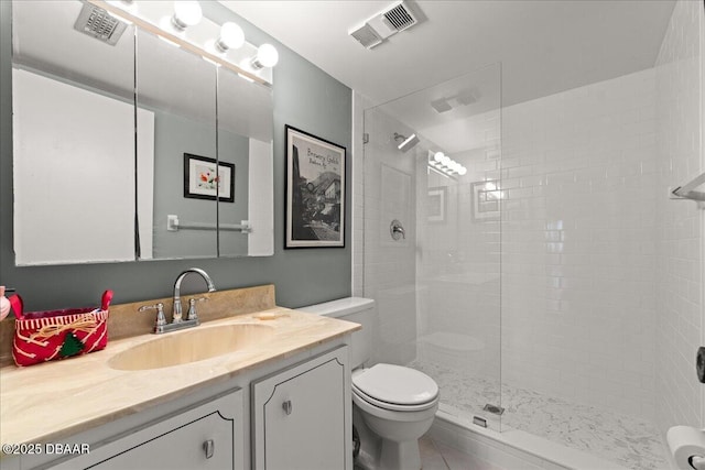 bathroom featuring tiled shower, vanity, and toilet