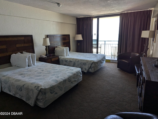 carpeted bedroom featuring access to outside and a textured ceiling