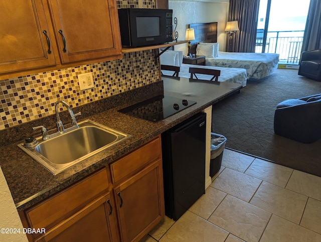 kitchen with light carpet, sink, black appliances, dark stone counters, and backsplash