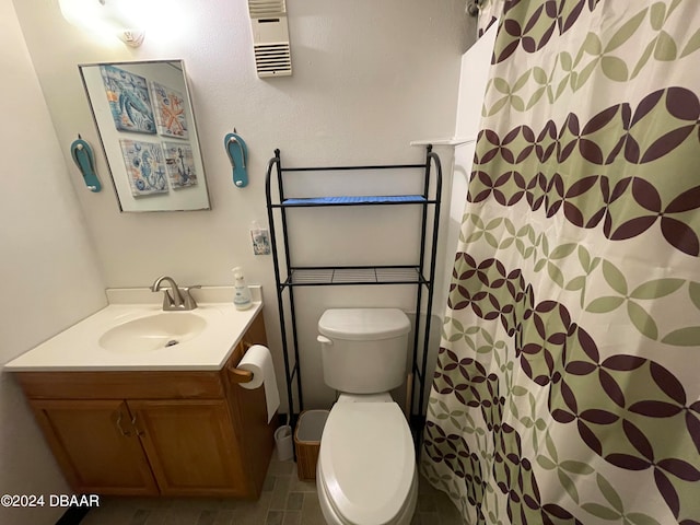 bathroom with walk in shower, vanity, and toilet