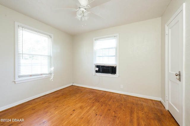 unfurnished room with cooling unit, hardwood / wood-style floors, and a healthy amount of sunlight