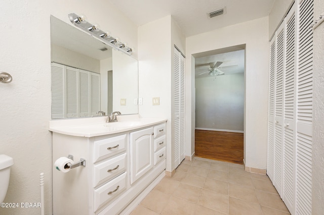 bathroom featuring toilet, vanity, tile patterned floors, and ceiling fan