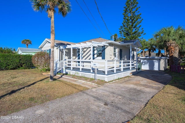 view of front facade featuring an outbuilding, a front yard, a wooden deck, and a garage