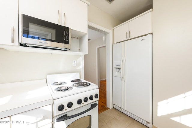 kitchen featuring white cabinetry, white appliances, and light tile patterned flooring