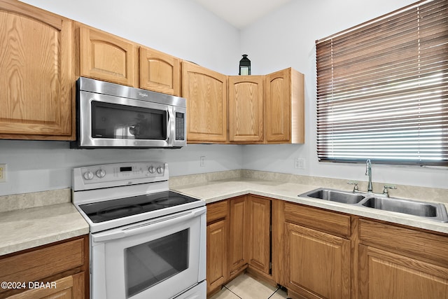 kitchen with sink, light tile patterned flooring, and white electric range