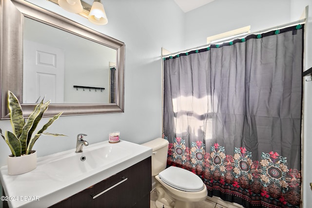 bathroom with tile patterned flooring, vanity, toilet, and curtained shower