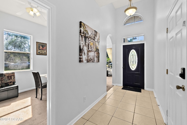 entrance foyer with ceiling fan, light tile patterned floors, and a towering ceiling