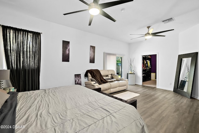 bedroom featuring ceiling fan, a closet, wood-type flooring, and a spacious closet