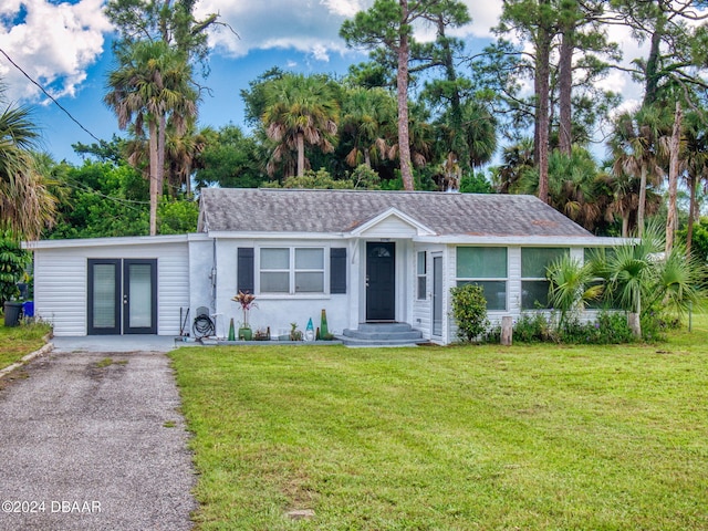 ranch-style house with a front yard and french doors