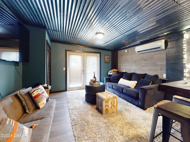 living room featuring lofted ceiling, wood walls, wood-type flooring, and a wall unit AC