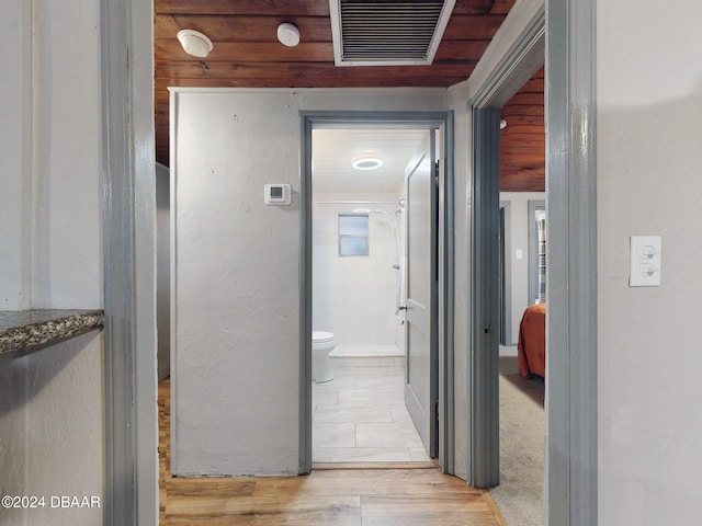 hall with light hardwood / wood-style flooring and wood walls