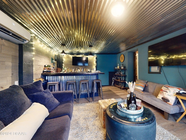 living room featuring bar area, wood-type flooring, and a wall mounted air conditioner