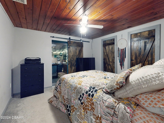 bedroom with a barn door, ceiling fan, light colored carpet, and wooden ceiling