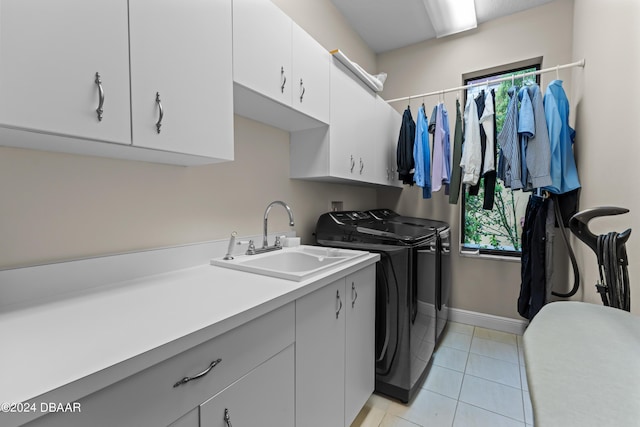 laundry room featuring cabinets, light tile patterned flooring, washer and clothes dryer, and sink