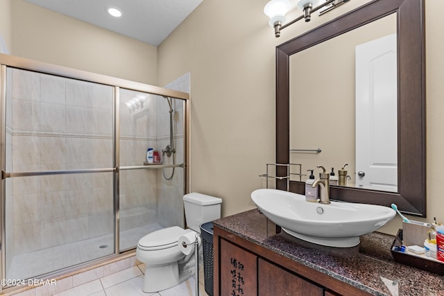 bathroom featuring tile patterned floors, vanity, toilet, and a shower with door