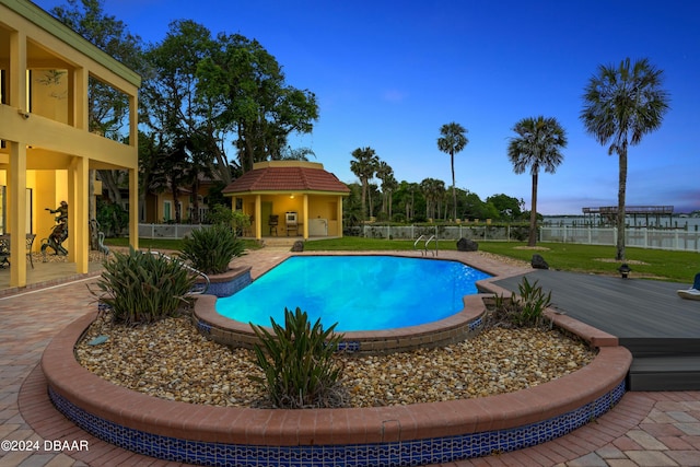 pool at dusk featuring a wooden deck