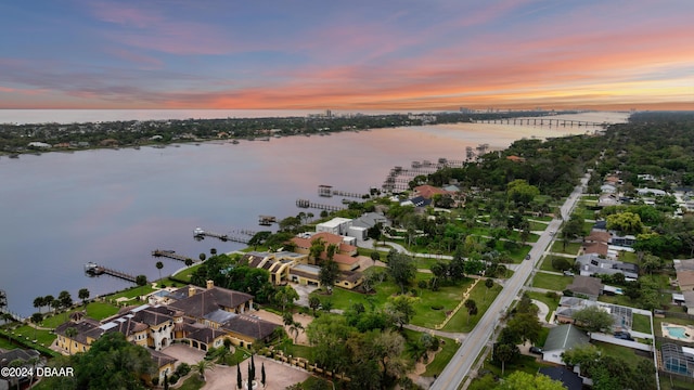 aerial view at dusk featuring a water view