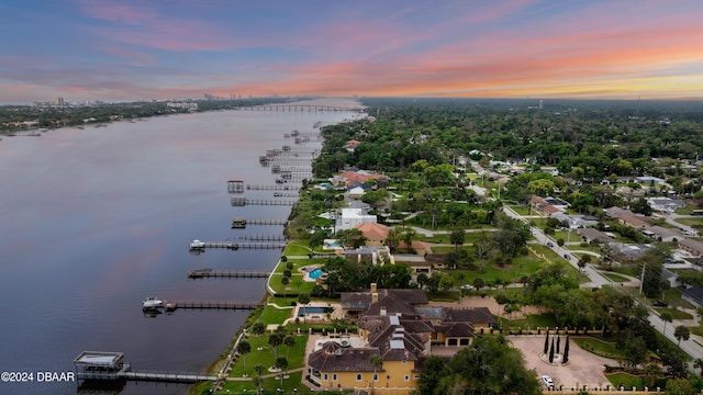 aerial view at dusk featuring a water view