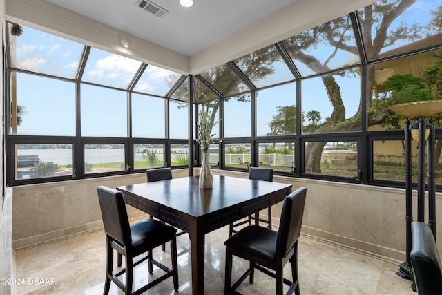 sunroom featuring a water view and a wealth of natural light