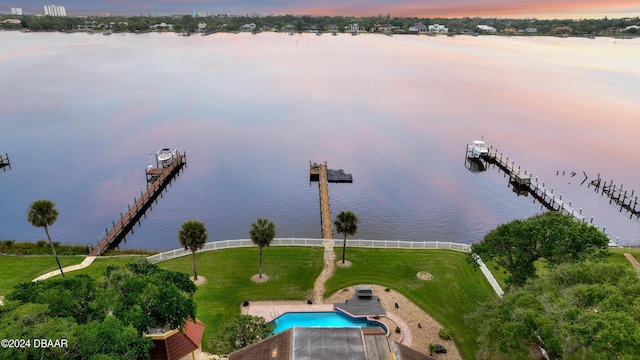 aerial view at dusk featuring a water view