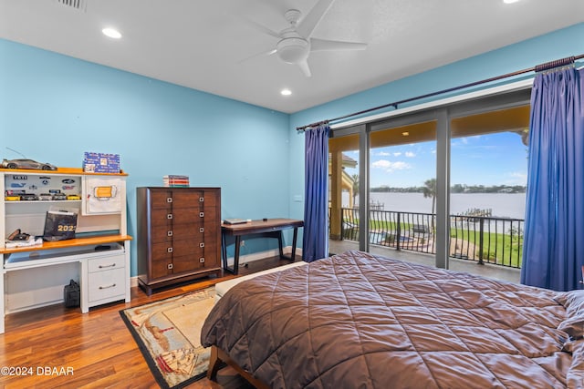 bedroom featuring access to exterior, ceiling fan, a water view, and wood-type flooring