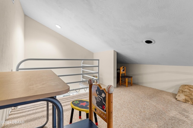 interior space with a textured ceiling, carpet, and lofted ceiling