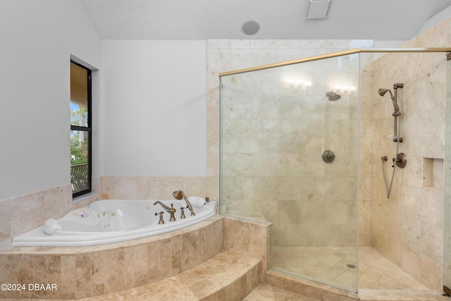 bathroom featuring independent shower and bath and a textured ceiling