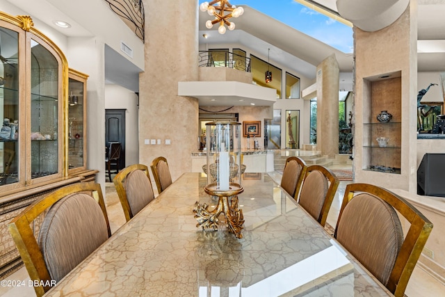 dining area featuring a notable chandelier and a high ceiling