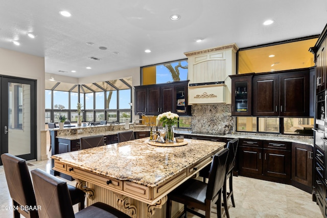 kitchen with a center island, dark brown cabinetry, and backsplash